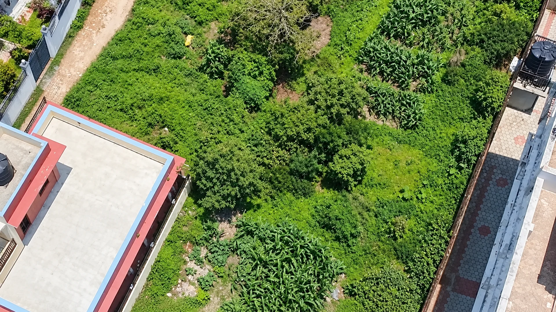 An aerial view of undeveloped residential land surrounded by buildings in Nepal.